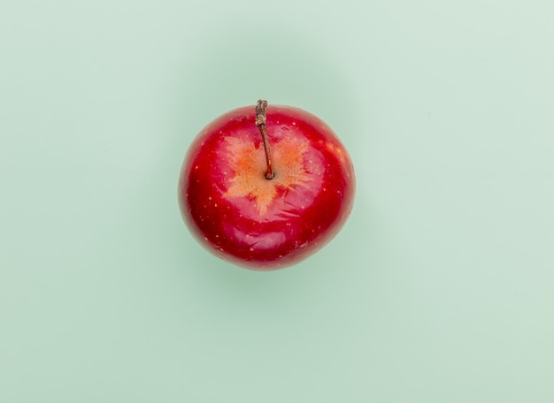 Top view of red apple on green background with copy space