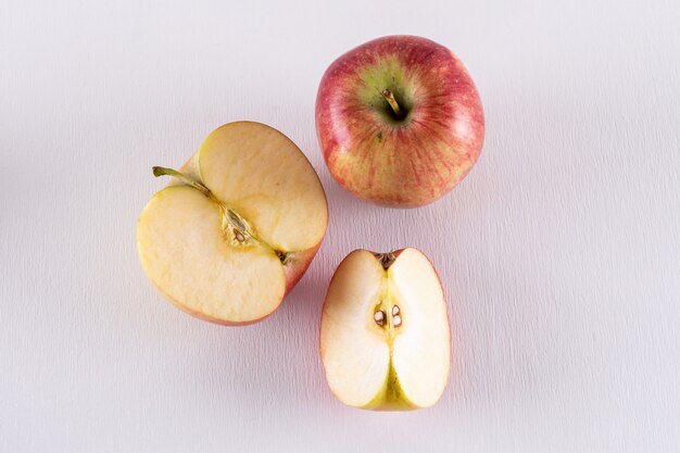 Top view red apples sliced on white  horizontal 1