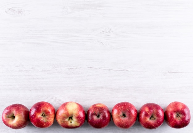 白い木製水平にコピースペースを持つトップビュー赤いリンゴ