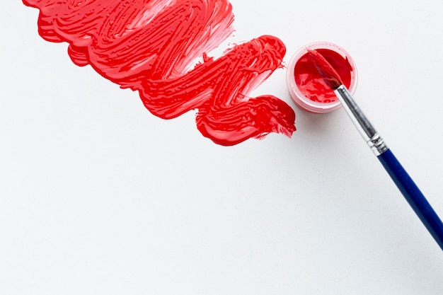 Top view of red aquarelle with brush