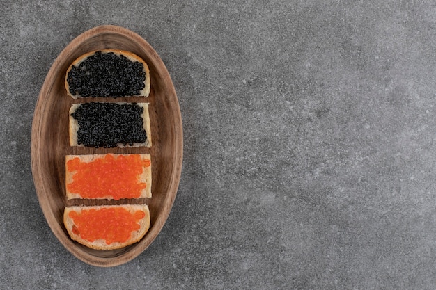 Free photo top view of red and black caviar sandwiches.