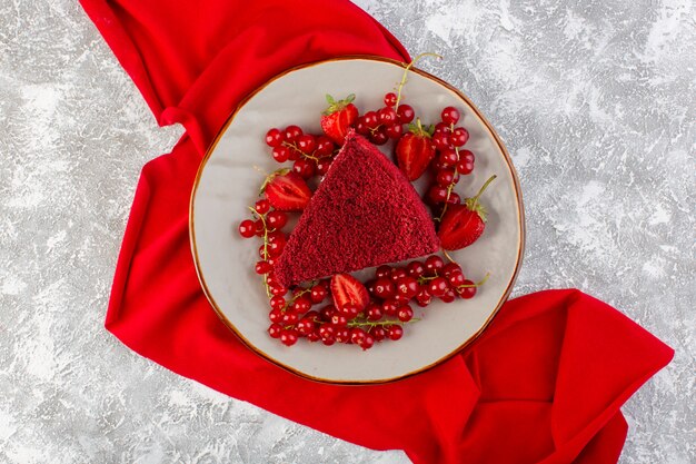 Top view red cake slice fruit cake piece inside plate with fresh cranberries and strawberries on the grey desk cake sweet biscuit tea