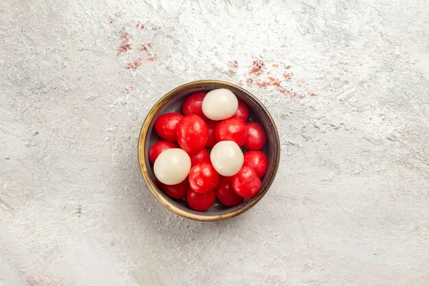 Top view red candies inside little plate on white background candy sugar bonbon goodie sweet