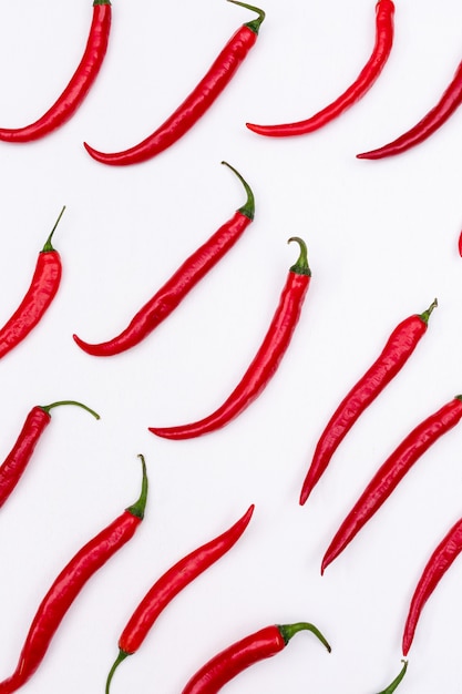 Free photo top view red chili pepper pattern on white  vertical