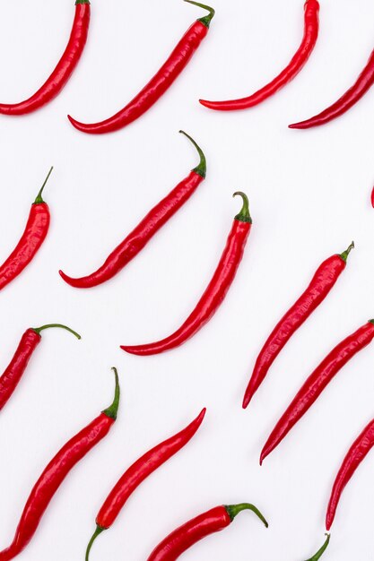 Top view red chili pepper pattern on white  vertical