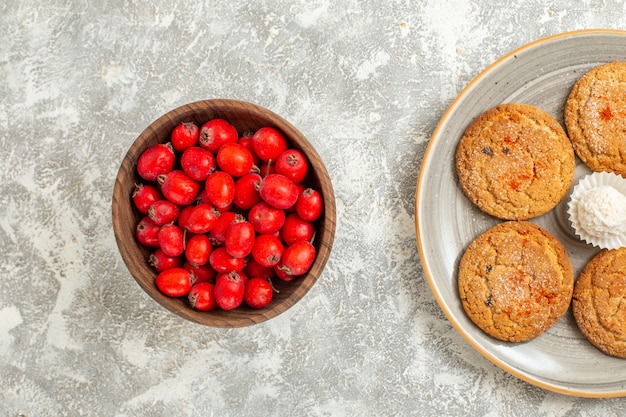 Top view red fruits with cookies on white background