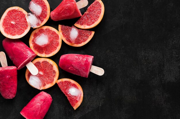 Top view of red grapefruit popsicles with copy space
