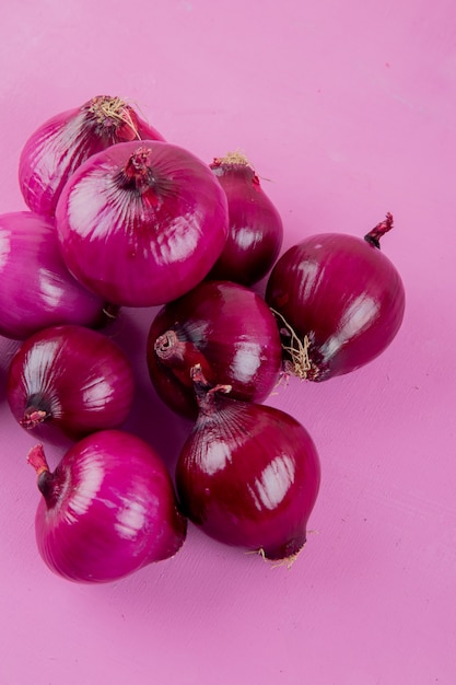 Free photo top view of red onions on purple background