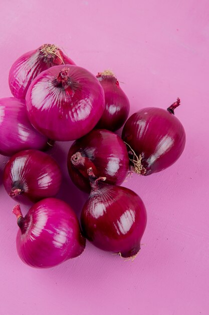 Top view of red onions on purple background