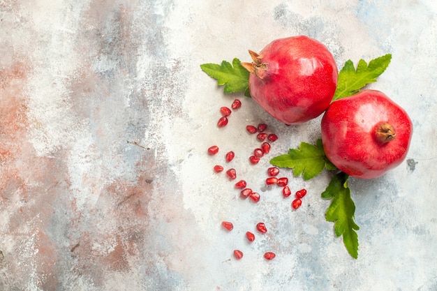 Top view red pomegranates pomegranate seeds on nude surface with copy space