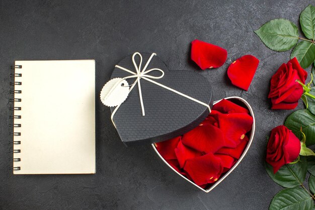 어두운 배경 사랑 여자 심장 커플 색상 열정 느낌에 발렌타인 데이 장미 꽃잎으로 가득 찬 상자와 상위 뷰 빨간 장미