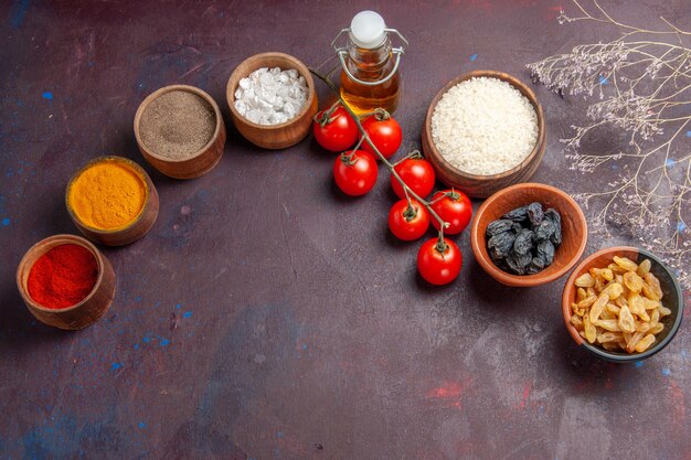 Top view red tomatoes with raisins and seasonings on dark background raisin vegetable salad health