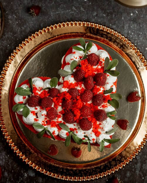 나무 딸기와 함께 garnished 심장 모양에 빨간 벨벳 케이크의 상위 뷰