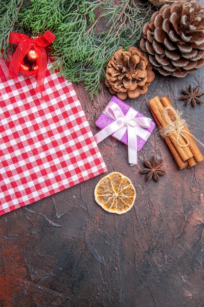 上面図赤と白の市松模様のテーブルクロス松の木の枝松ぼっくりクリスマスギフトシナモンクリスマスツリーボールおもちゃ濃い赤の表面