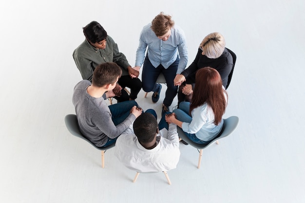 Top view rehab patients holding hands