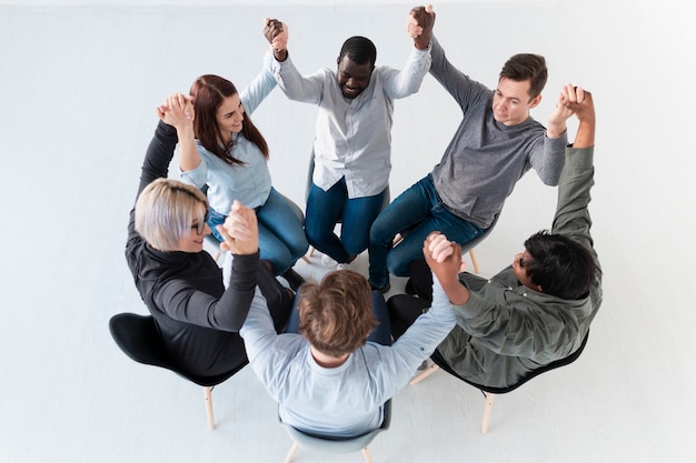 Free photo top view rehab patients raising hands