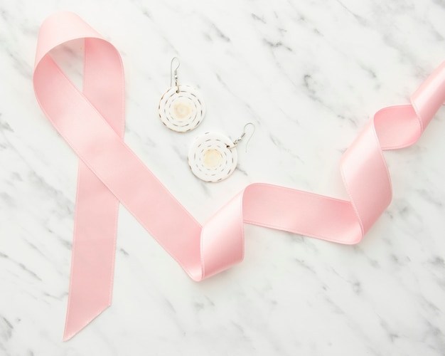 Top view ribbon and earrings on marble table