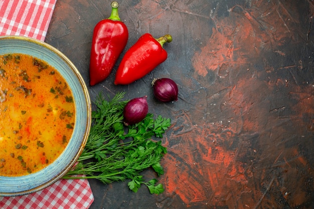 Top view rice soup in bowl on red white checkered tablecloth red peppers onions parsley on background