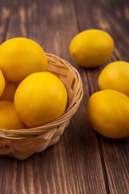 木製の壁に隔離されたレモンとバケツに豊富なビタミンCレモンの上面図