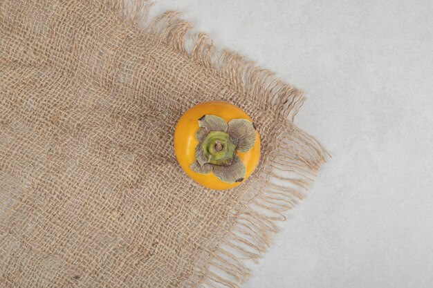Top view of ripe delicious persimmon on burlap