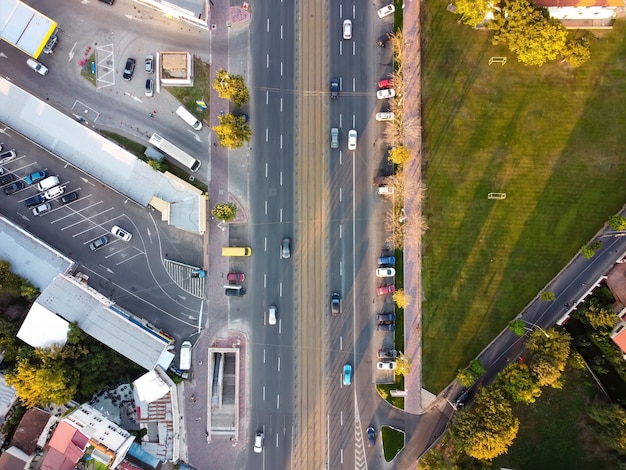 Top view of a road in Bucharest, multiple cars, parking, green lawn on the right, view from the drone, Romania