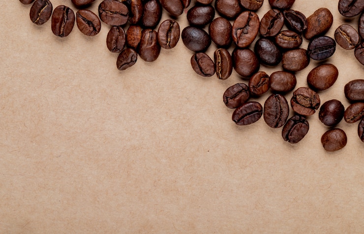 Free Photo top view of roasted coffee beans scattered on brown paper texture background with copy space