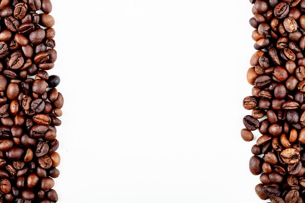 Top view of roasted coffee beans on white background with copy space