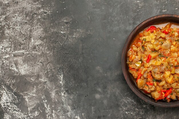 Top view of roasted eggplant salad in bowl on dark surface