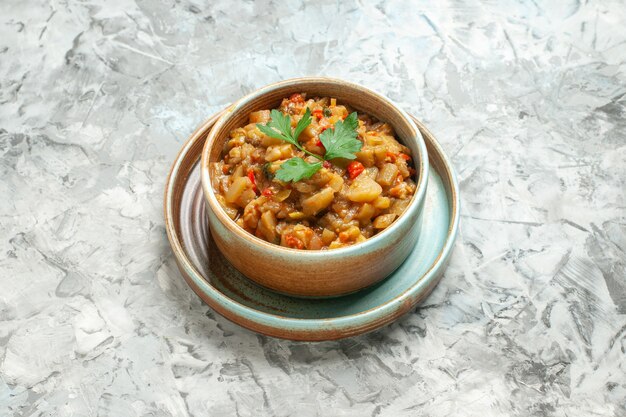 Top view of roasted eggplant salad in bowl on grey surface