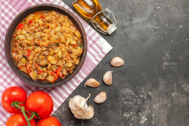 Vista dall'alto di insalata di melanzane arrosto in una ciotola sulla superficie a scacchi bianco rosa