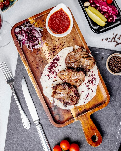 Top view of roasted meat pieces on a wooden board