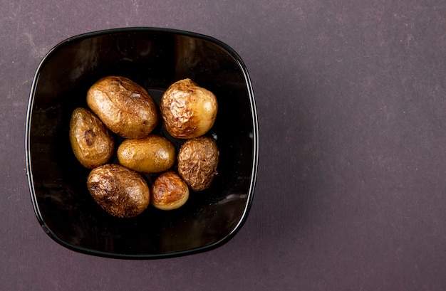 Top view roasted potatoes on the left with copy space on grey background