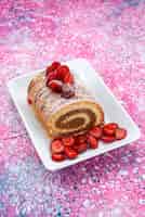 無料写真 色付きの背景のケーキビスケット甘い色の白いプレート内の赤いイチゴと平面図ロールケーキ