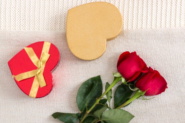 Top view roses and heart shaped box of candies in bed