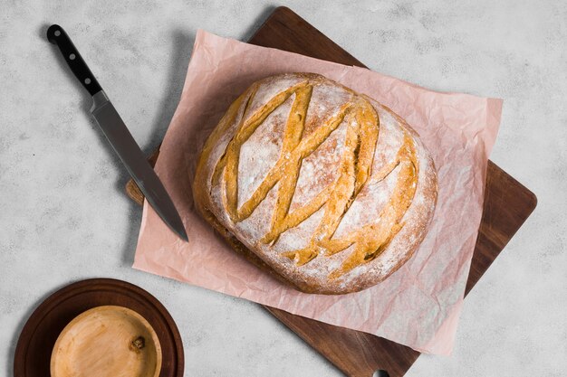 Top view round bread with knife on baking paper