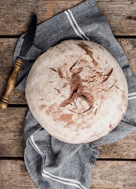 Top view round bread with knife on cloth