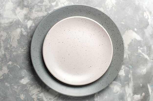 Top view of round empty plate grey colored with white plate on grey surface