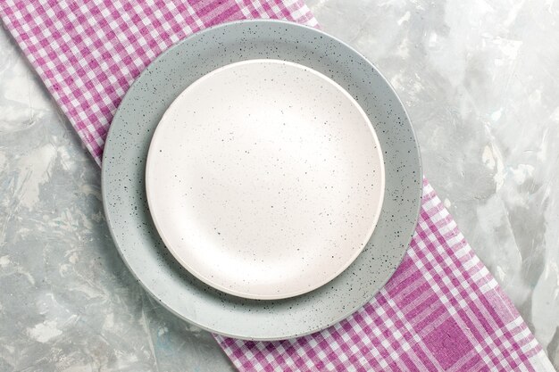 Top view of round empty plate grey colored with white plate on grey surface