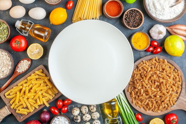 Top view round empty plate with raw pasta flour vegetables seasonings and eggs on dark table food color egg milk dough dinner meal fruit