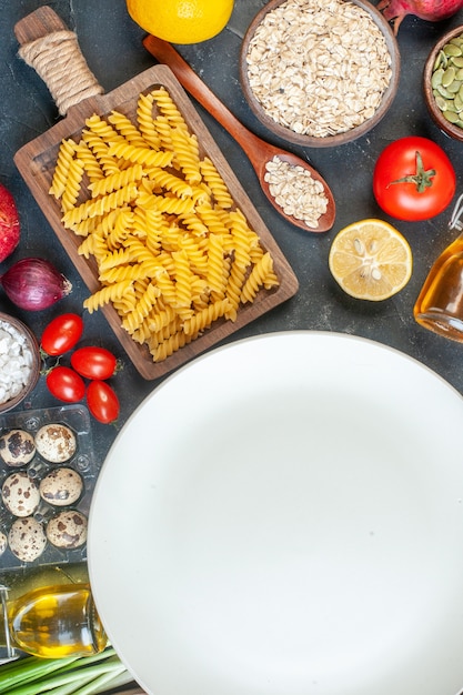 Top view round empty plate with raw pasta flour vegetables seasonings and eggs on the dark table food color egg milk dough dinner meal fruit