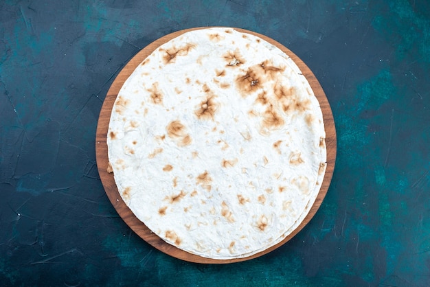 Free photo top view of round plain pita baked bread like dough on dark blue surface