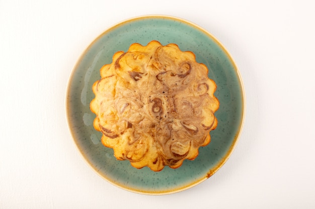 Free photo a top view round sweet cake delicious yummy cake inside blue plate on the white background sugar tea biscuit bake