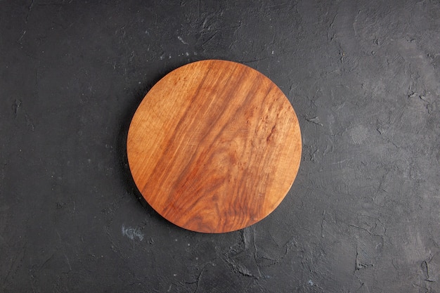 Top view round wood board on dark background