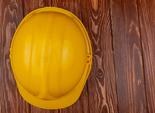 Top view of safety helmet on wooden background with copy space