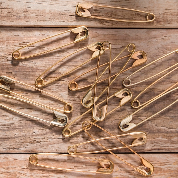 Free photo top view of safety pins on wooden surface