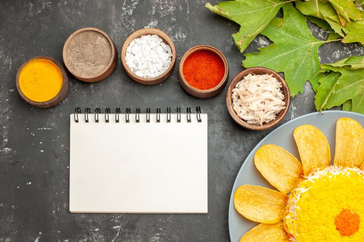 Free Photo top view of salad on the bottom side with herbs notepad and leaves on side on dark grey background