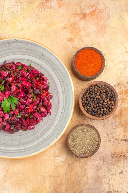 Foto gratuita insalata vista dall'alto su un piatto di ceramica con pepe nero macinato pepe nero curcuma su uno sfondo di legno con copia posto