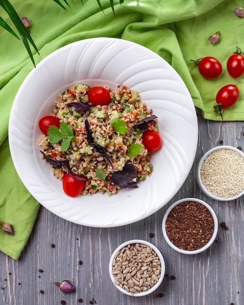 Top view salad of seeds sesame seeds flax and sunflower seeds with tomatoes and basil