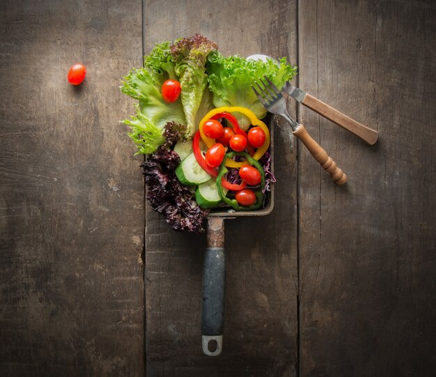 Top view of salad with cherry tomatos on wooden table