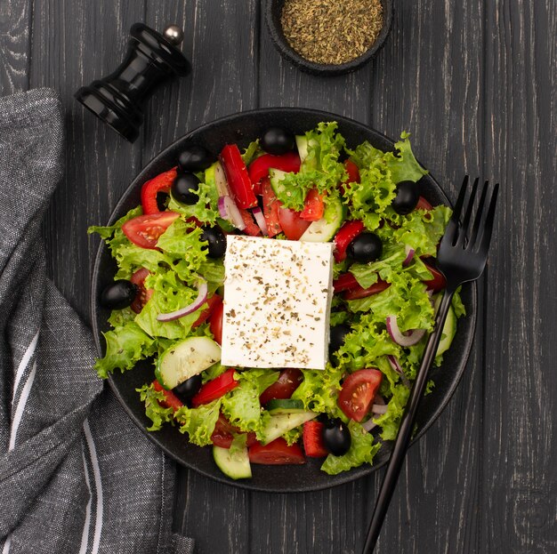 Top view salad with feta cheese, herbs and fork